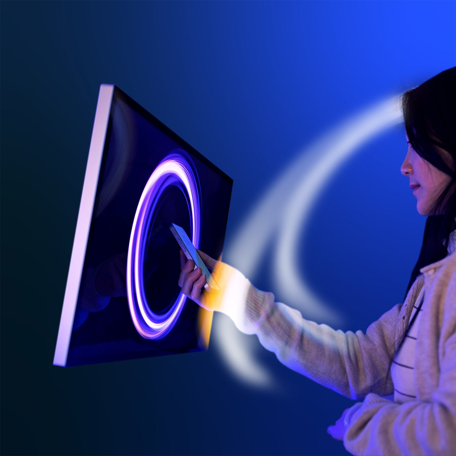 Woman interacting with circular patterned light swirling around and a screen with a similar light pattern displayed.