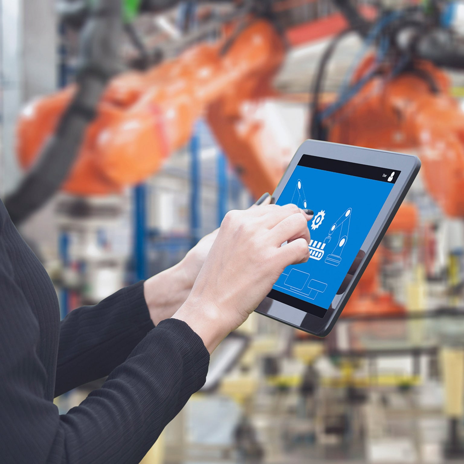 Close up view of a tablet with someone pointing to an image featuring advanced manufacturing technology.